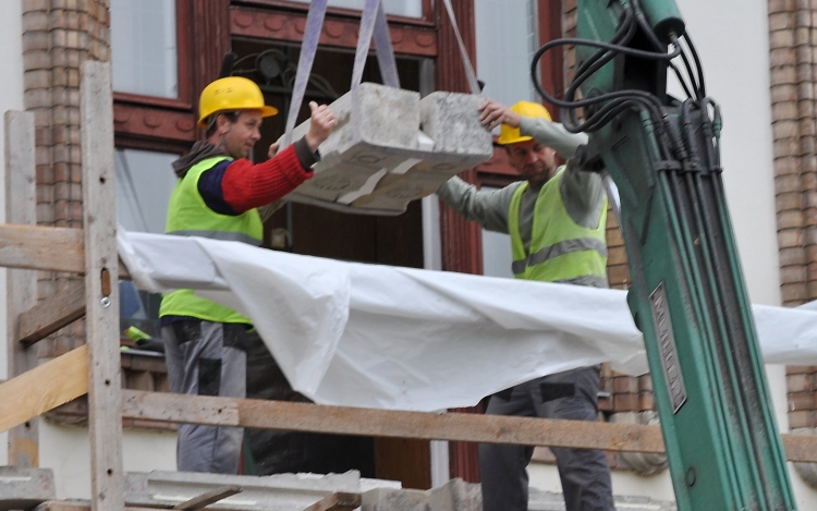 Kőfaragók dolgoznak a Városháza erkélyén